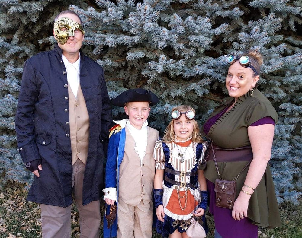 A family of four wears travel themed costumes including, Steampunk, a colonial Englishman, and the Phatom of the Opera.