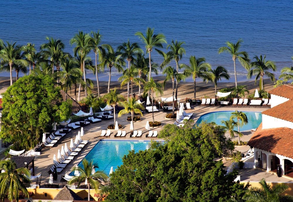 An aerial view of Club Med Ixtapa Pacific, featuring tropical foliage, a large pool, and an expansive beach. Knowing where to stay is critical to our important information on Mexico.