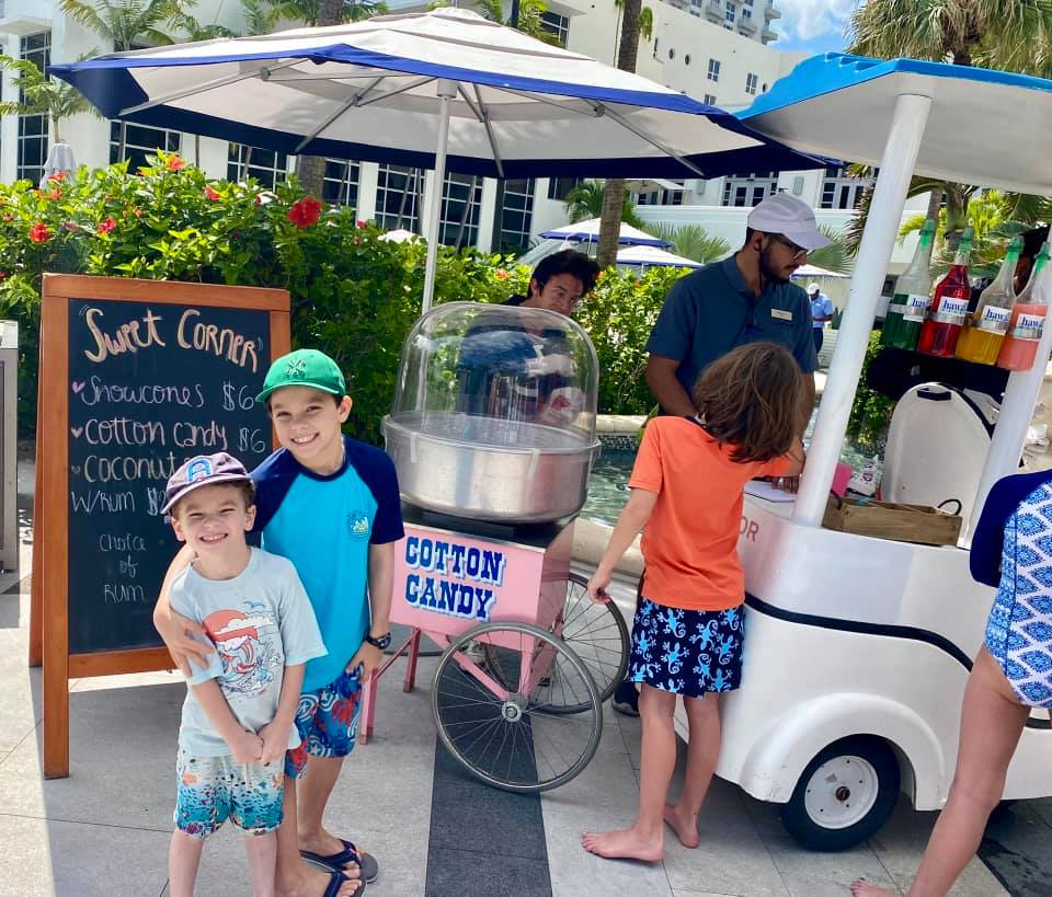 Two young kids stand in front of an on-site cotton candy vendor at the Loews Miami Beach Hotel in Florida.