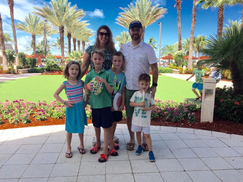 Two parents and their four kids stand smiling at the JW Marriott Marco Island.