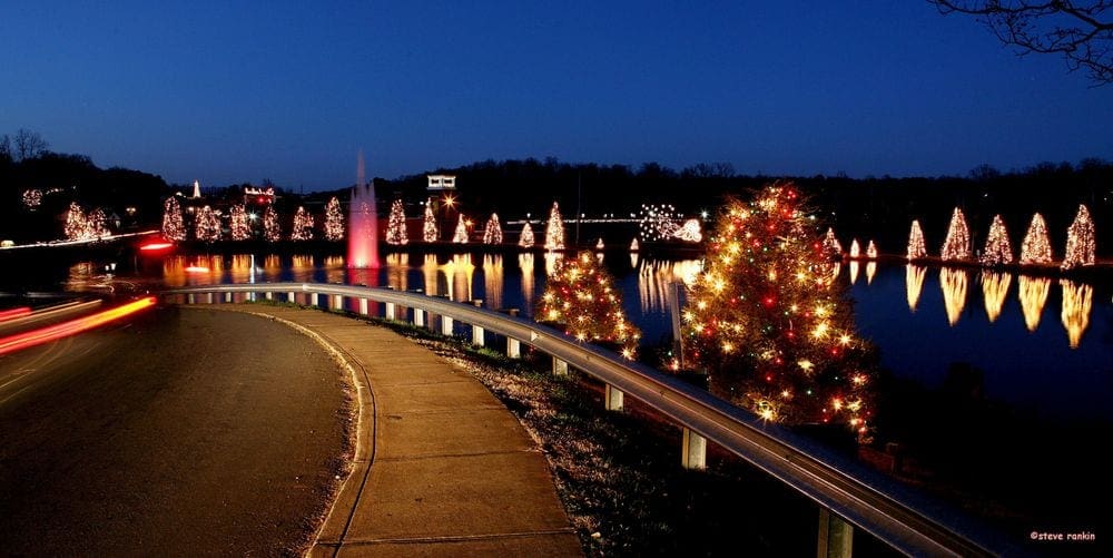 Christmas Town Lake in McAdenville, North Carolina, is flanked by dozens of Christmas trees with colorful lights.