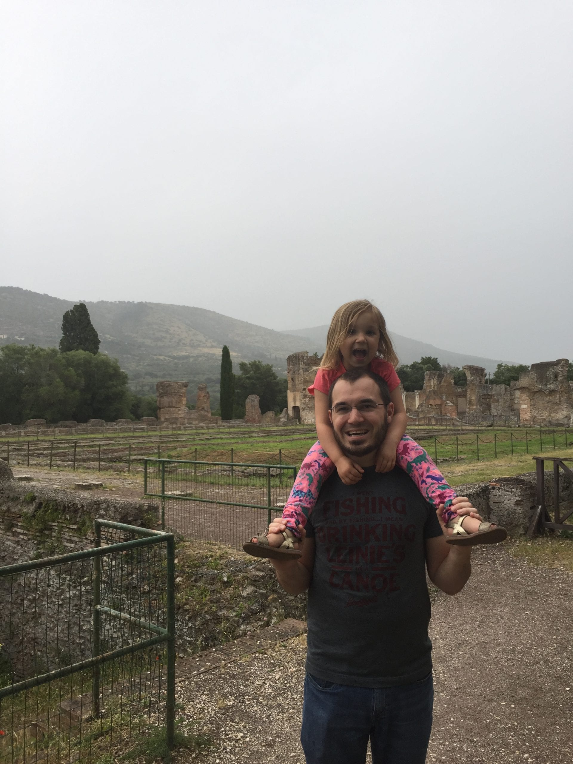 A young girl rides on her father's shoulder inside Hadrian's Villa near Rome, certainly among the best of Rome with toddlers.