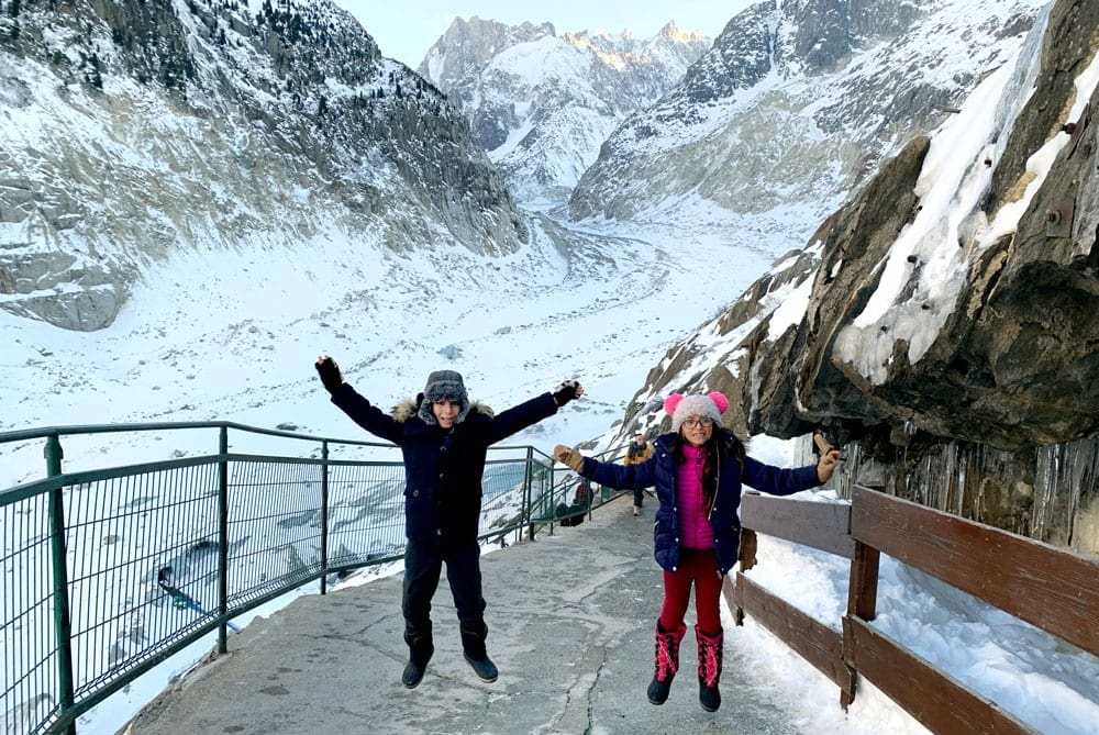 Two kids jump on a montain path near Charmonix.