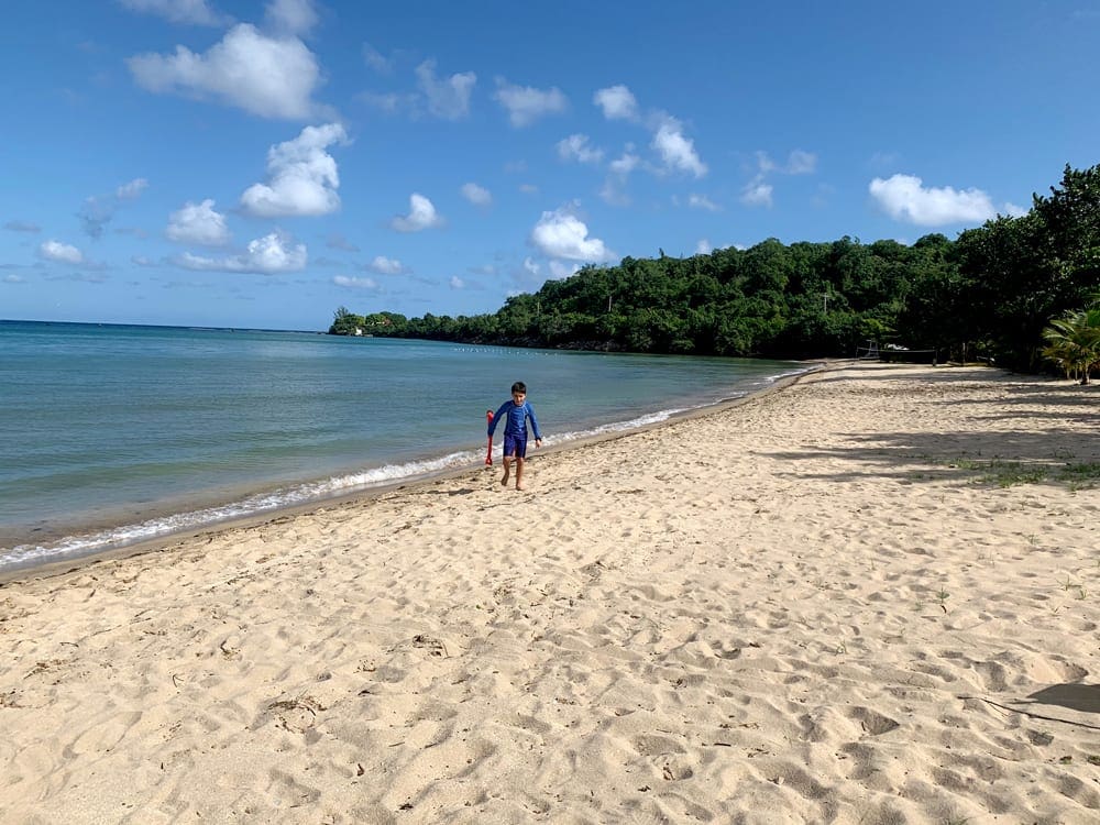 A young boy runs along a beach in Jamaica.