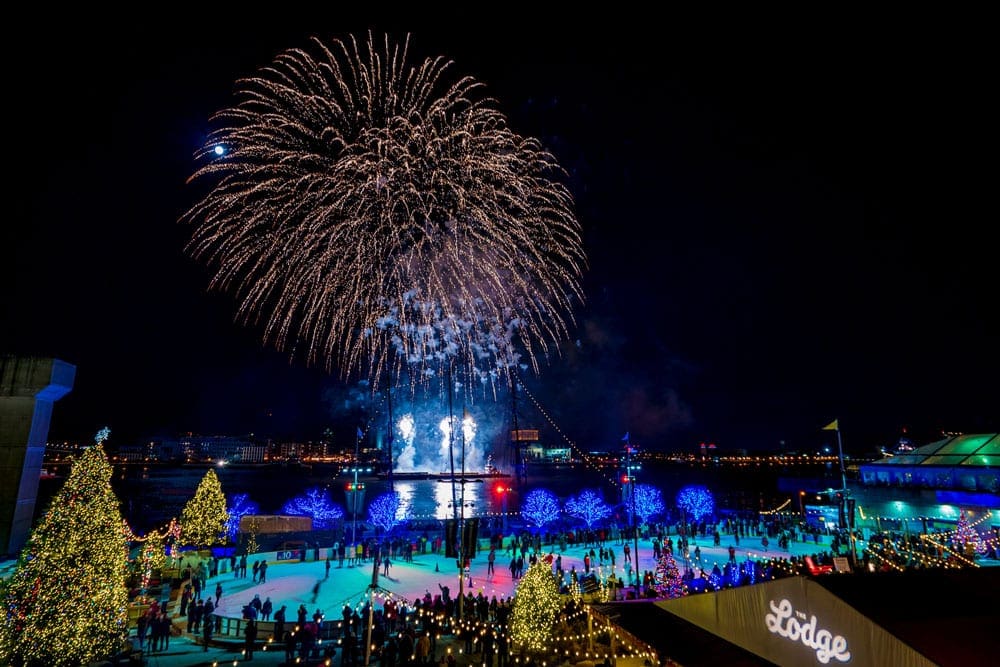 Several fire works go off over an ice rink inside a park in Philadelphia, one of the best things to do in Philadelphia with kids this winter.