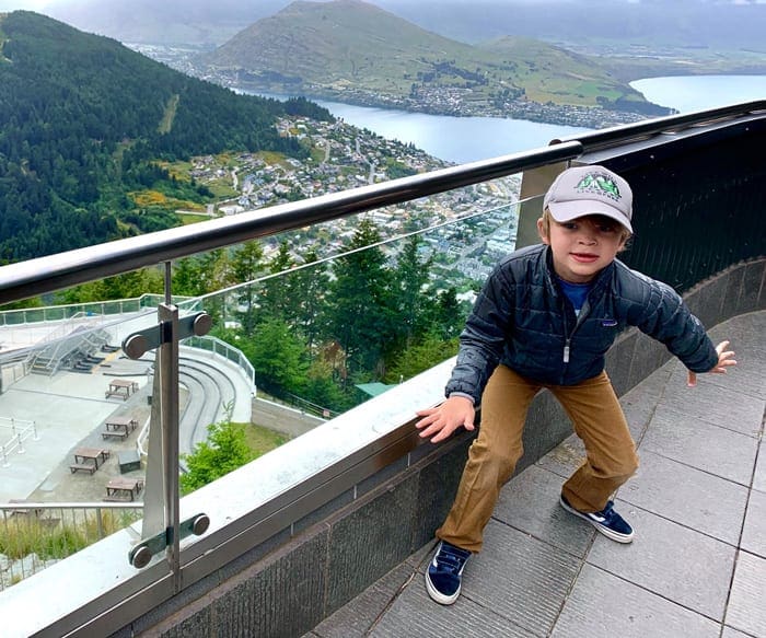 A young boy stands next to the luge in Queenstown, while exploring New Zealand with his family.