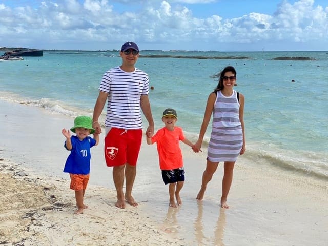 A family of four holds hands while walking on the beach near the Fairmont Mayakoba in Playa del Carmen, one of the best resorts in Playa del Carmen.