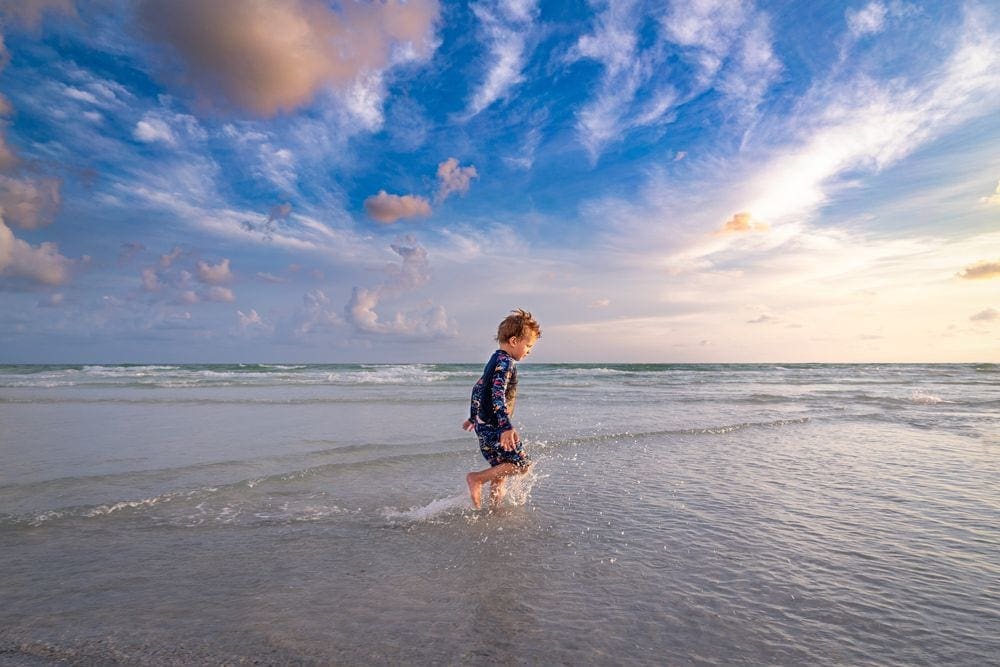 A young boy splashes through the water on the beach in the Florida Keys.