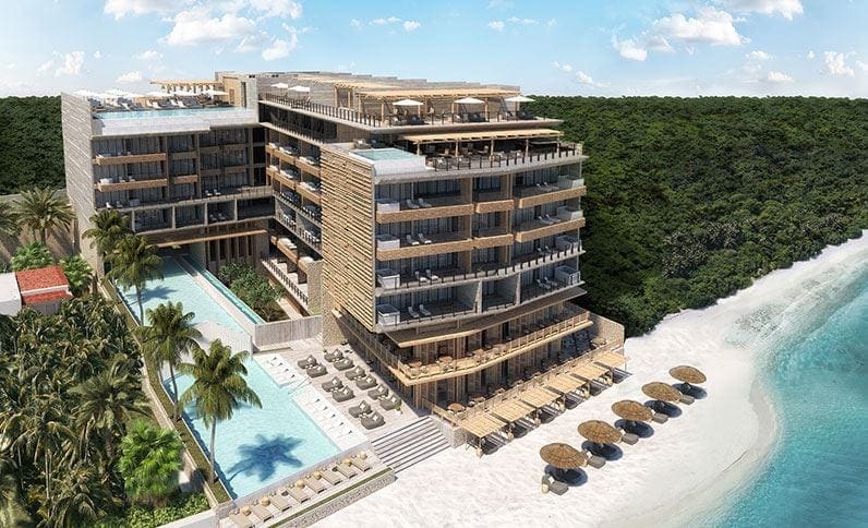 An aerial view of The Fives Azul Beach Resort Playa del Carmen, featuring a large hotel, pool, and beach access.
