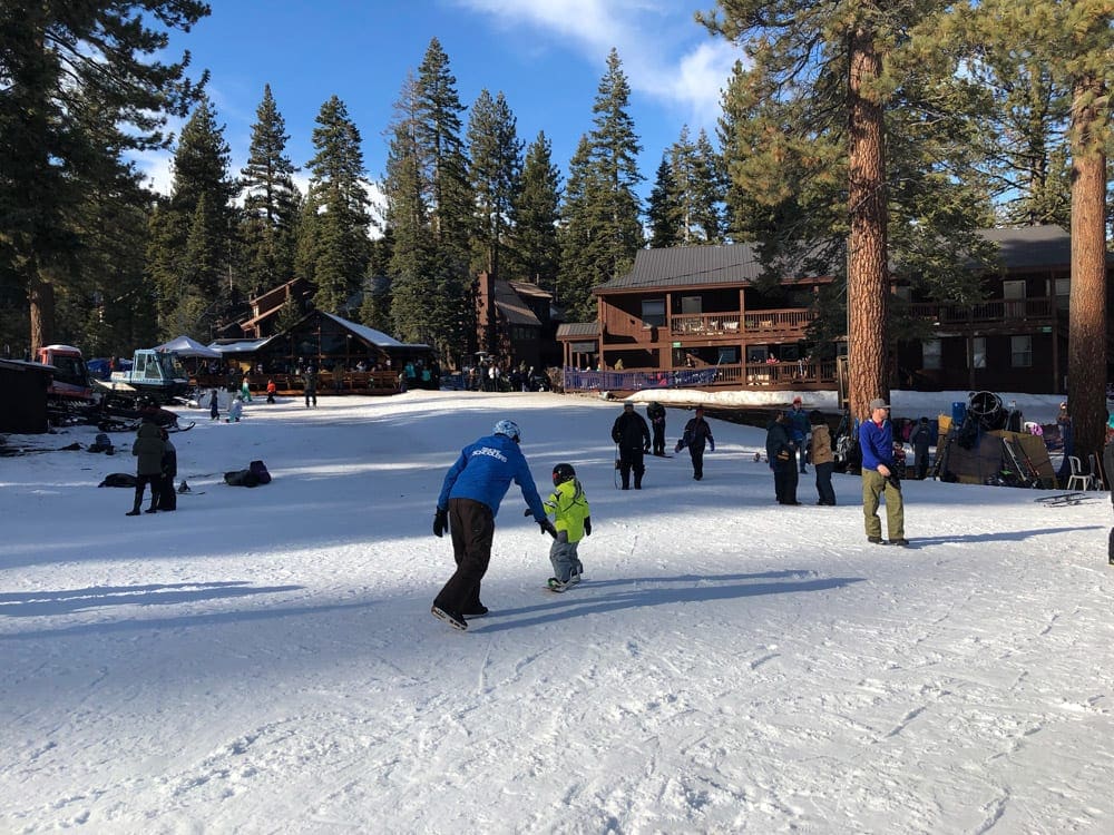 A snowboarding instructor leads a young child during a lesson at Granlibakken Tahoe City.