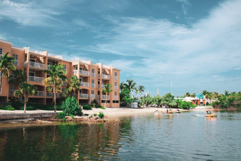 Beachfront view of the Key West Marriott Beachside property lined with palm trees and water sports, one of the best family hotels in Key West and the Florida Keys.