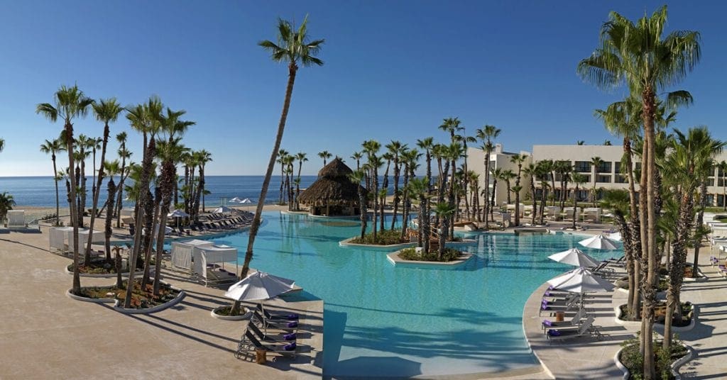 On the grounds of the Paradisus Los Cabos, including a large pool, hotel buildings, and palm trees.