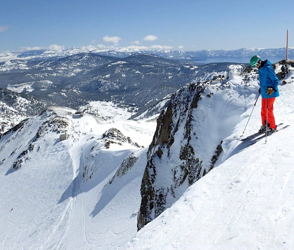 A teen stands on the edge of a huge slope in Squaw Valley.