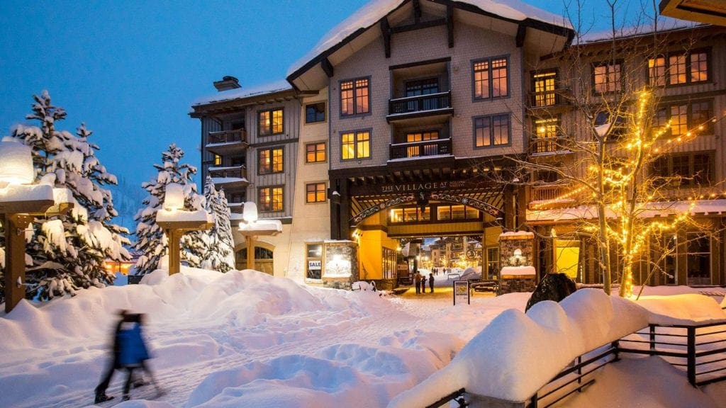 A night view of Village at Squaw Valley, while one couple strolls by.