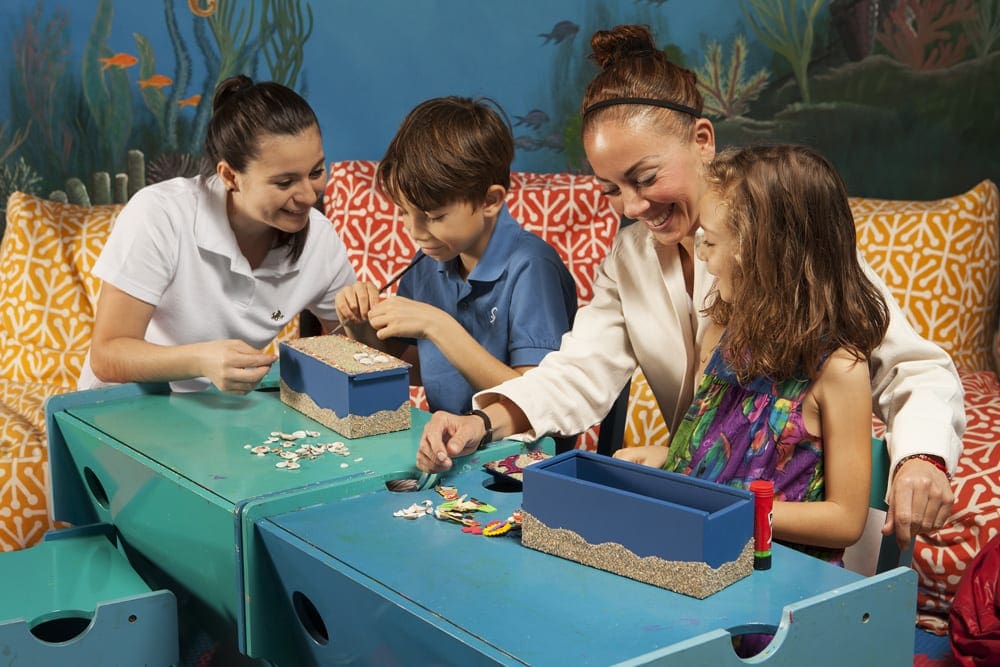 Two kids create crafts with two Kids Club staff members at Waldorf Astoria Los Cabos Pedregal.