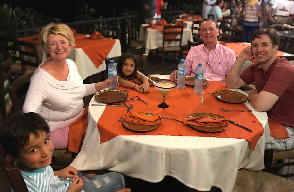 Three adults and two kids dine comfortably in Cancun.