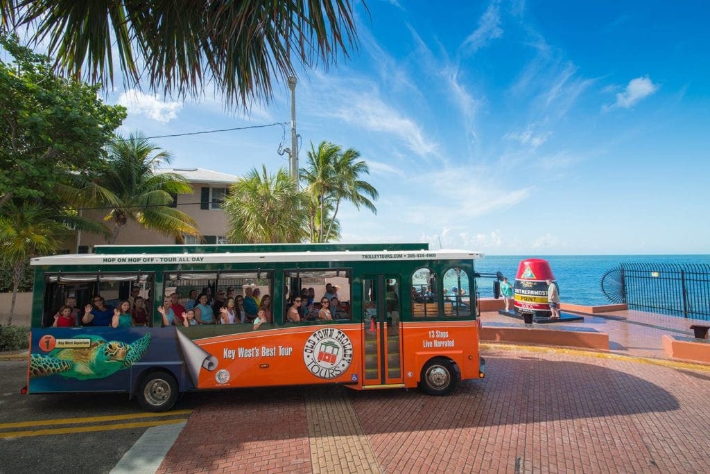 The Old Town Trolley bus tours through Key West on a sunny day.