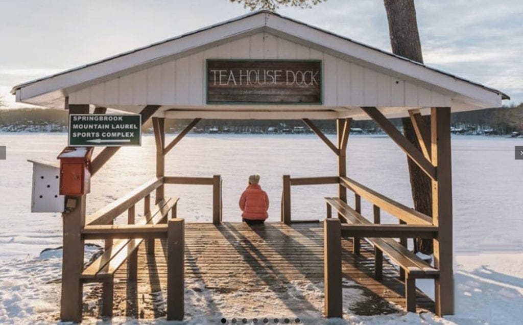 kids sitting on the dock and the lake is frozen