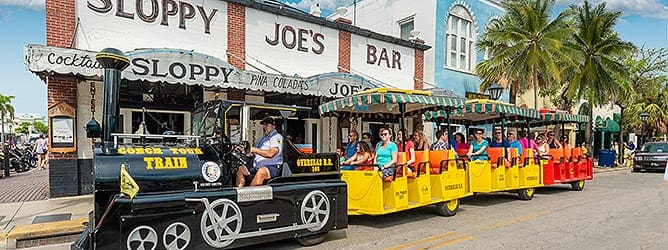 The Conch Tour Train begins movie with train cars filled with tourists exploring Key West.