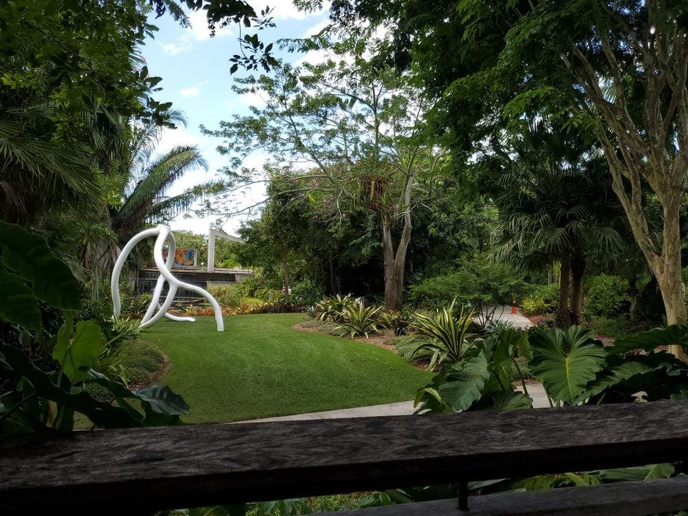 A lush botanical garden, featuing a large white statue.