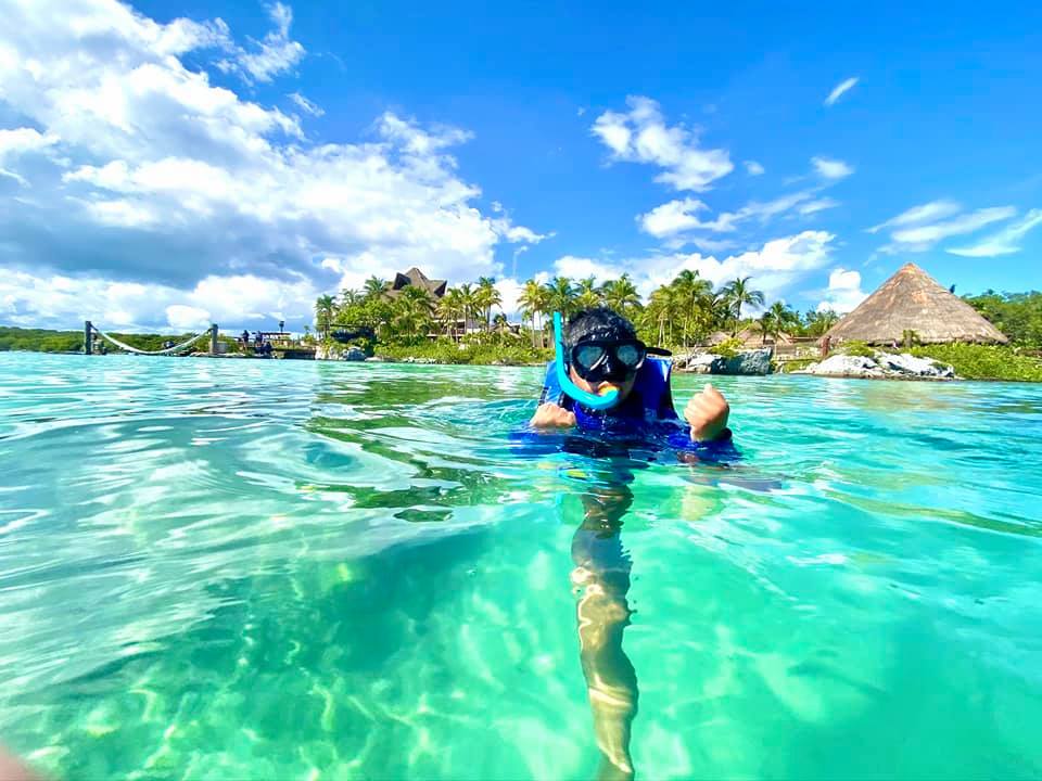 A young boy snorkels in Mexico on a sunny, clear day, one of the best spring break destinations for families around the world.