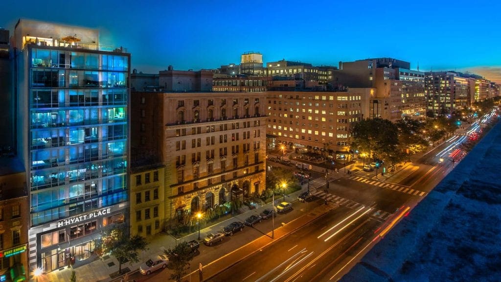 An aerial view of the Hyatt Place Washington DC/White House and surrounding buildings at night.