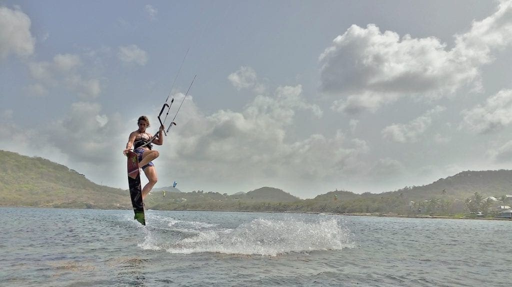 A woman jumps along the waves while kitesurfing in St. Lucia.
