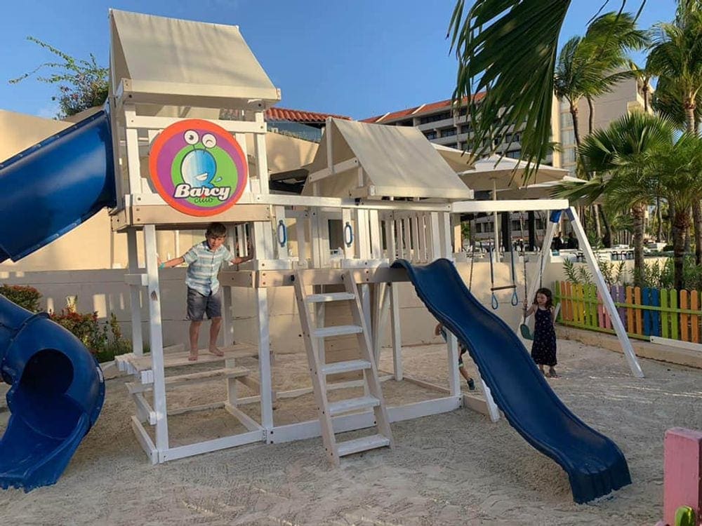 Two kids play on the playground at the Barcelo Aruba.