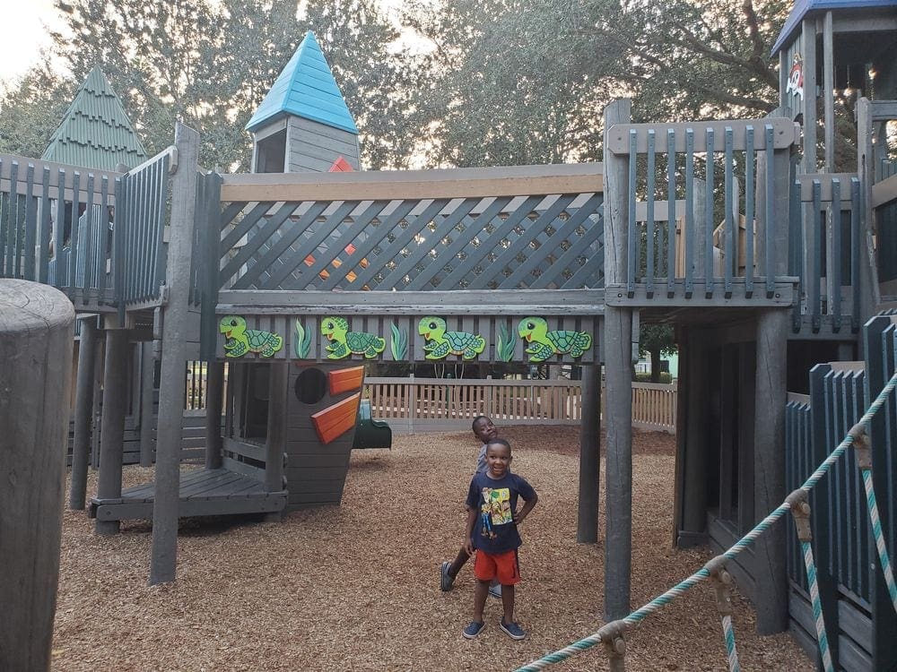 Two young black boys enjoy playing at a playground in Naples.