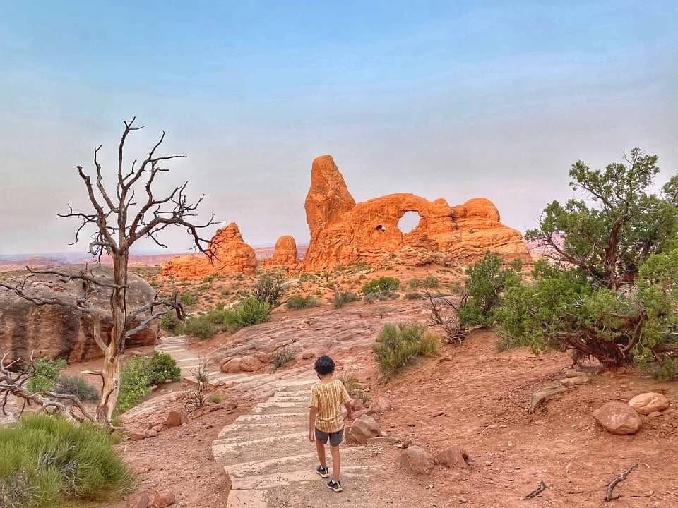 A young boy wanders a stone path in Arches National Park.