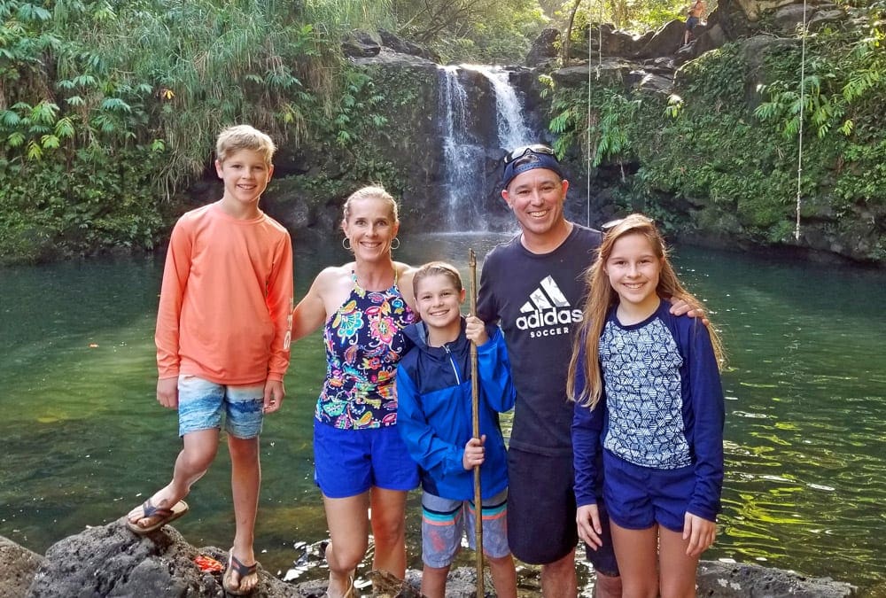 A family of five stands on the Road to Hana in Maui, one of the best islands in Hawaii for kids.