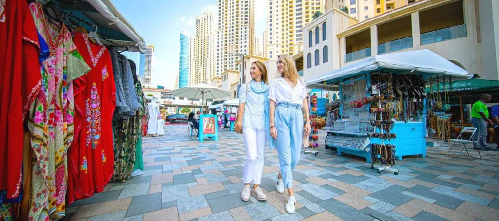 A mother and her daughter stroll the JBR Walk in Dubai.