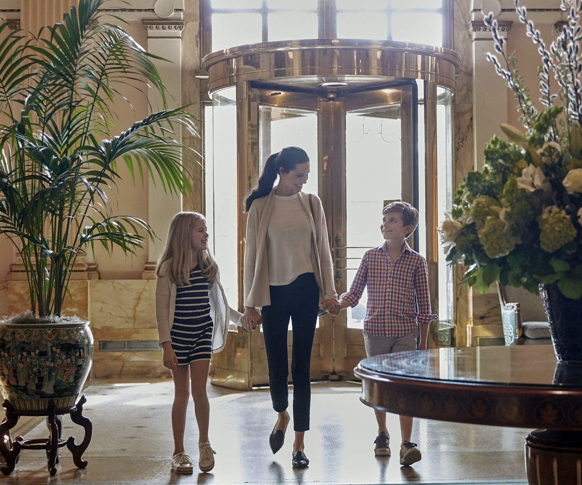 A mom holds her childrens hands as they enter the Willard InterContinental in Washington DC.