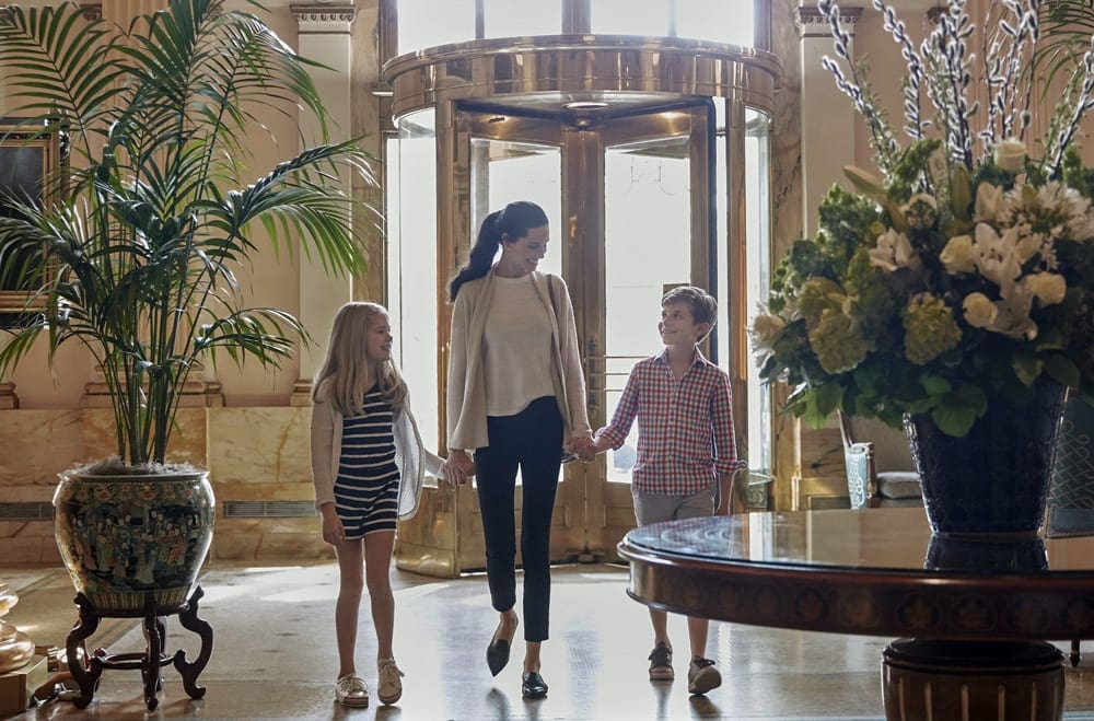 A mom holds her childrens hands as they enter the Willard InterContinental in Washington DC.