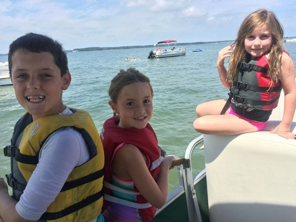 Three kids ride along in a pontoon of Rehoboth Beach.