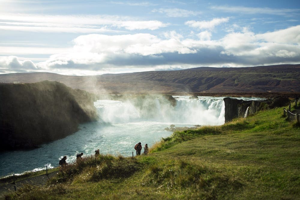 A view of a waterfall in Iceland on a clear, sunny day.