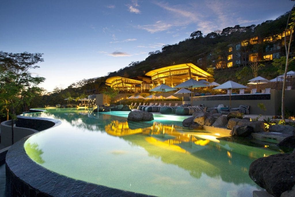 The pool outside of the Andaz Costa Rica Resort at Peninsula Papagayo hotel buildings at night, one of the best Costa Rica resorts for a family vacation.
