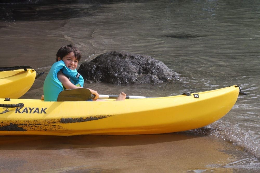 A young boy kayaks in a yellow kayak while staying at the Andaz Costa Rica Resort at Peninsula Papagayo.