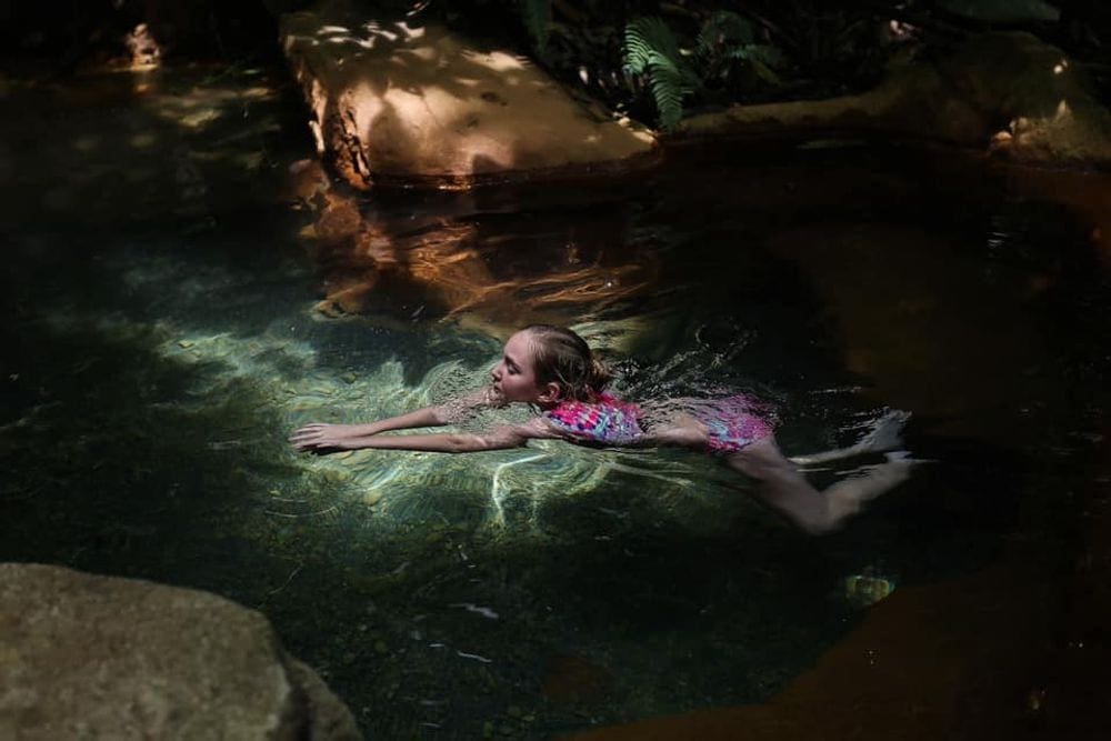 A young girl swims along a hot spring in Costa Rica.
