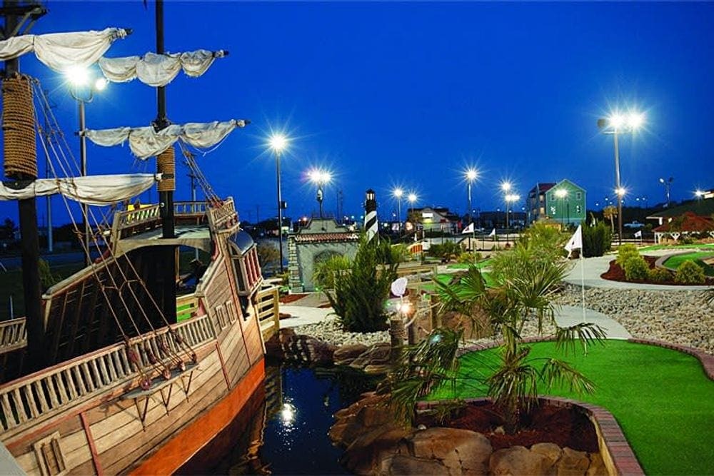 A view of the Paradise Golf Arcade at night, featuring a few of the mini-golf holes.