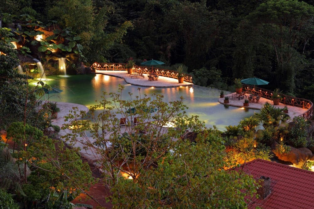 An aerial view of the pool at night at Peace Lodge, La Paz Waterfall Gardens, one of the best Costa Rica resorts for a family vacation.
