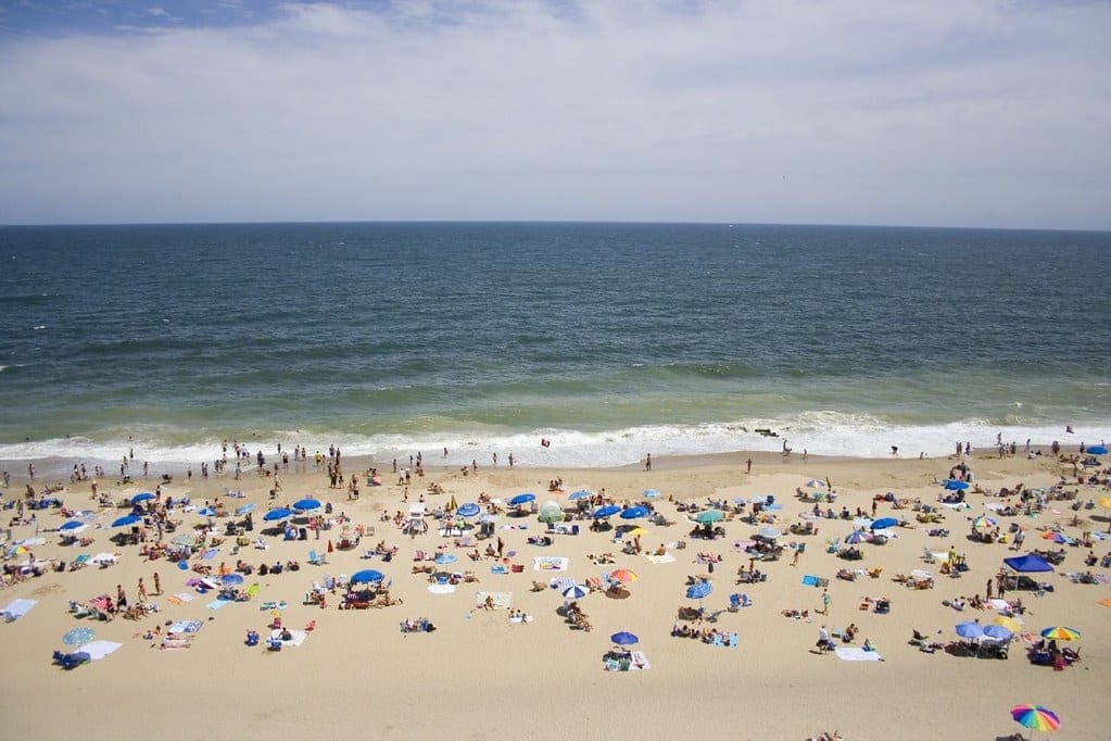 Rehoboth Beach filled with visitors and beach umbrellas on a sunny day, one of the best Memorial Day Weekend getaways from Washington DC for families.