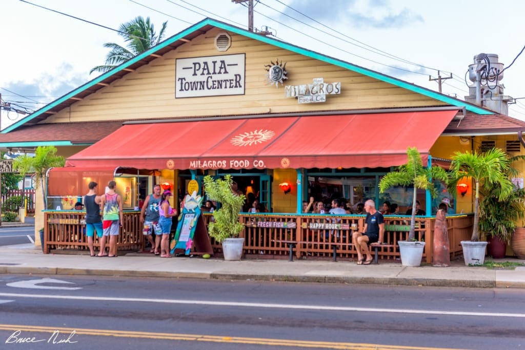 Several people linger outside Paia Town Center on an overcast day, which is a great place to stop on the Road to Hana with kids.
