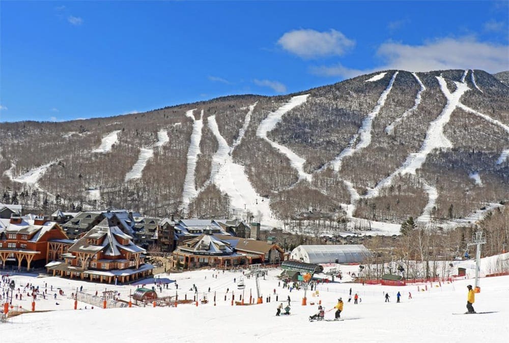 The lodge and ski runs on a sunny day at The Lodge at Spruce Peak in Vermont, one of the best ski-in/ski-out resorts in the U.S. for families
