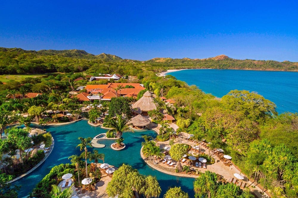 An areial view of The Westin Reserva Conchal, an All-Inclusive Golf Resort & Spa, one of the best Costa Rica resorts for a family vacation, featuring lush foliage and clear blue waters.