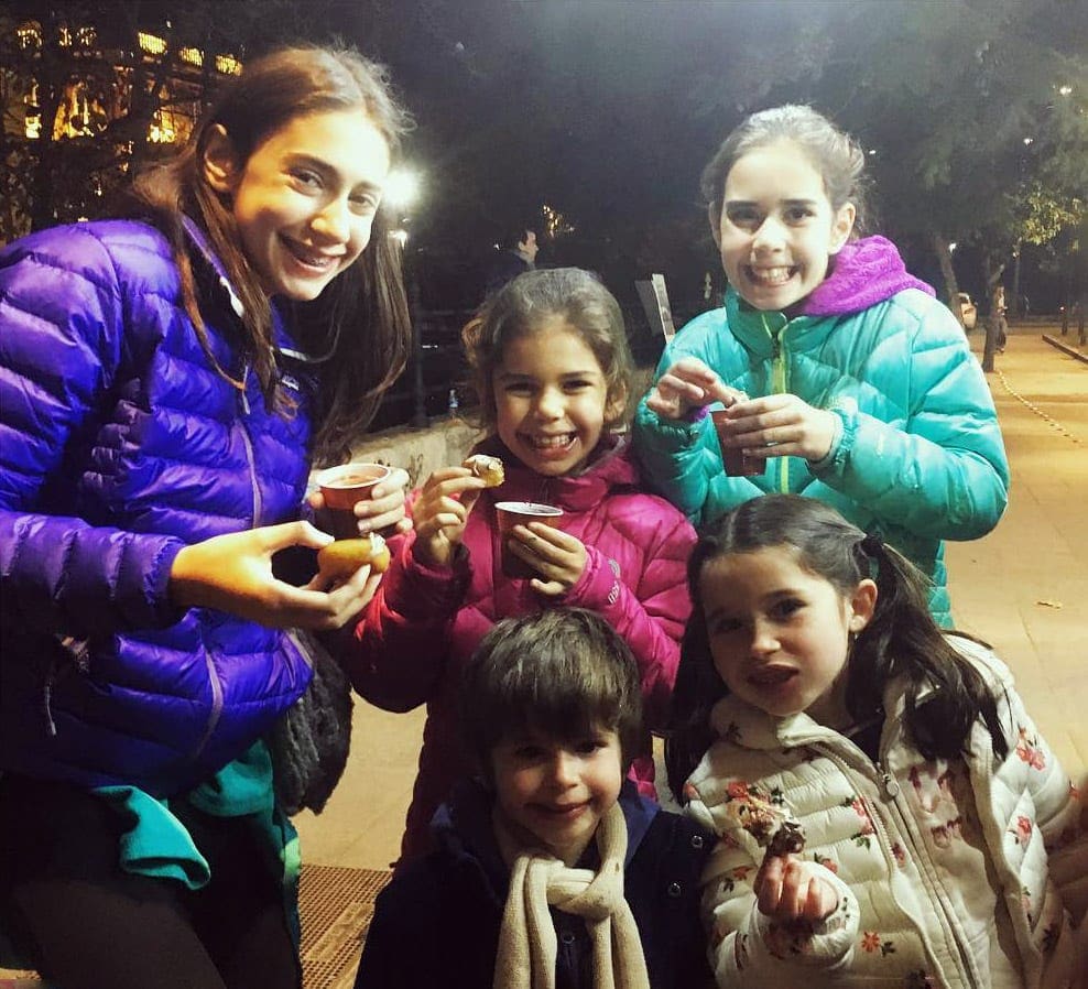 Two kids enjoy churros, one of the best foods to try while in Seville with kids.