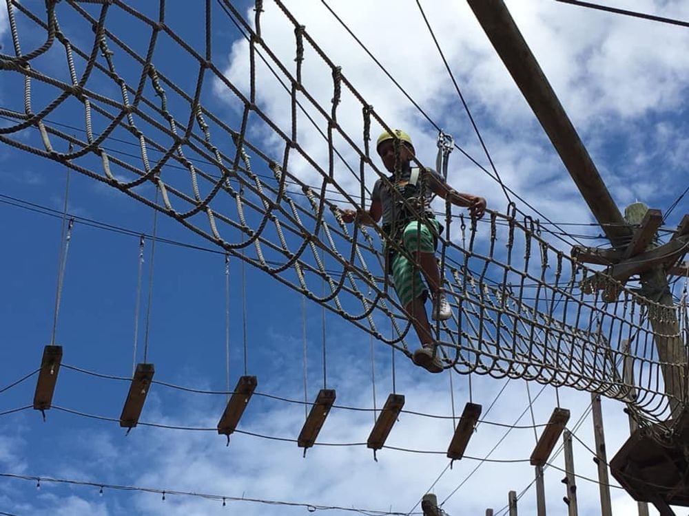 A person walks along a net zipline at Wild Blue.