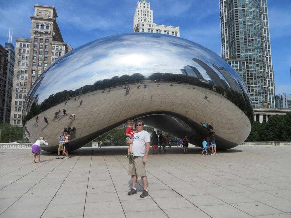 A dad holds his young son in front of "the Bean" in Chicago.