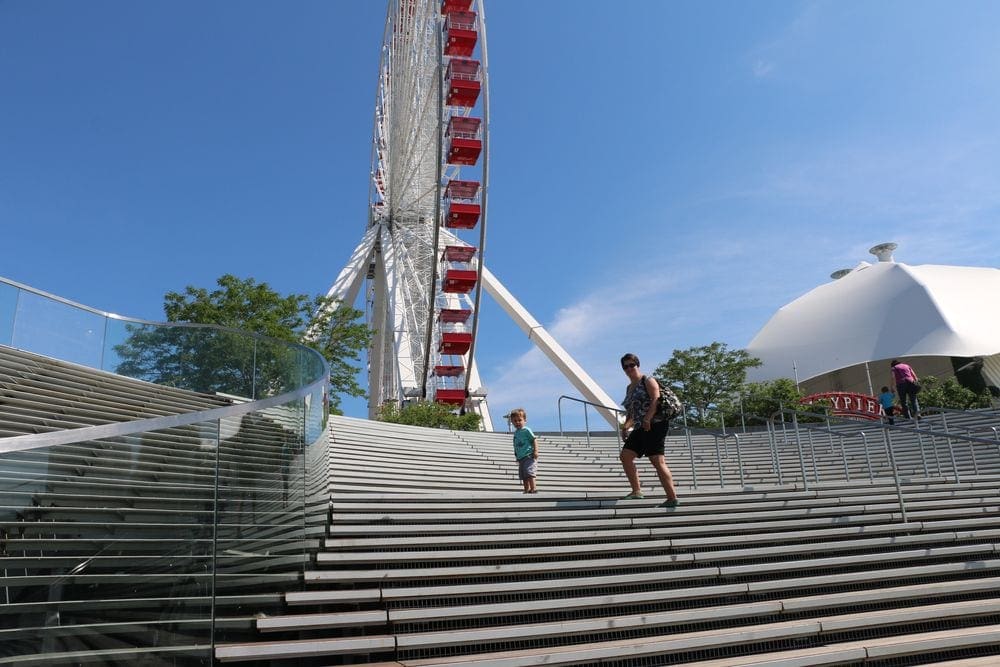 A young boy and his mom climb the stairs toward the ferris wheel inside Navy Pier, one of the best kids activities in Chicago.