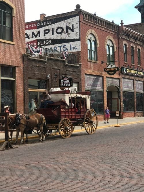 A stage coach with horse rests on the side of the road in the city of Deadwood, South Dakota.